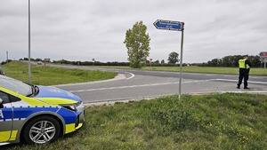 policjant stoi na drodze z miernikiem w ręku