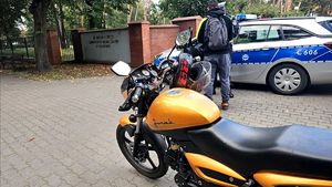 na pierwszym planie motocykl w tle policjant kontroluje kierowcę