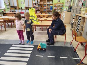 policjantka patrzy jak dzieci przechodzą przez pasy