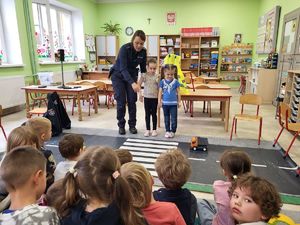 policjantka przeprowadza dzieci przez pasy
