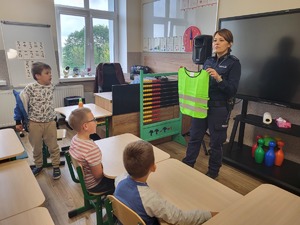 policjantka pokazuje dzieciom kamizelkę