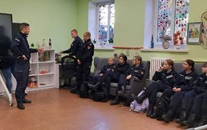 policjant na lekcji z kadetami zwraca się do umundurowanej kadetki