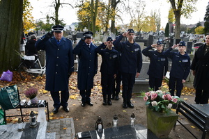 Policjanci i kadeci oddają honor nad grobem