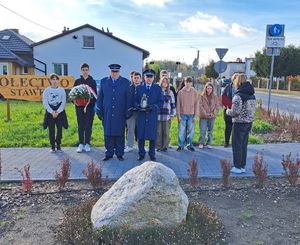 uczniowie wraz policjantami stoją przed tablicą