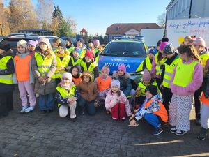 dzieci stoją przy radiowozie