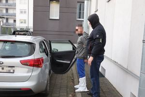 policjant stoi przy samochodzie z zatrzymanym