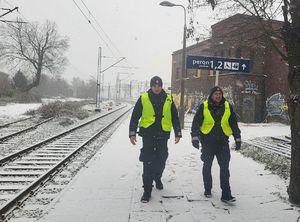 policjanci idą wzdłuż torowiska