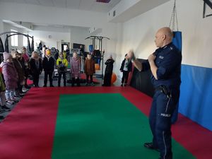 policjant demonstruje omiatanie pałką