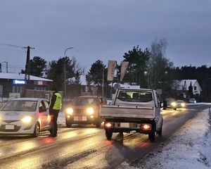 policjant przeprowadza badanie alkomatem na drodze
