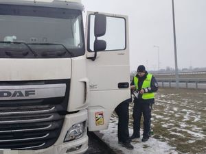 policjant stoi przy ciężarówce