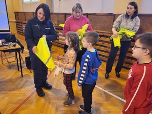 policjantka daje dziecku odblaski
