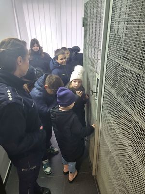 policjantka pokazuje dzieciom pomieszczenie dla zatrzymanych