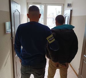 policjant stoi z zatrzymanym