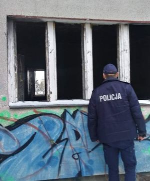 policjant zagląda do okna pustostanu