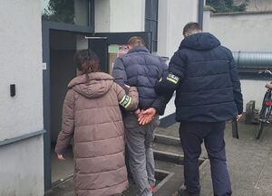 policjanci prowadzą zatrzymanego