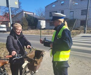 policjantka wręcza odblask rowerzyście