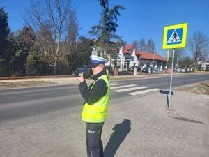 policjantka mierzy prędkość w rejonie przejścia dla pieszych