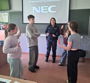 uczniowie stoją przy policjantce