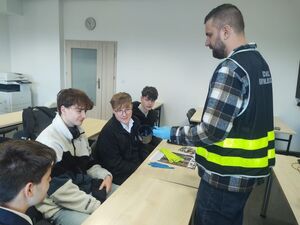 technik pokazuje uczniom jak pobiera ślady z kubka