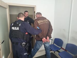 policjanci wyprowadzają zatrzymanego