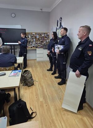 policjanci stoją w klasie przed uczniami