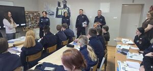 policjanci rozmawiają z uczniami w klasie