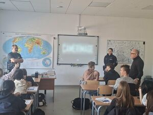 dzielnicowa stoi w klasie przed uczniami