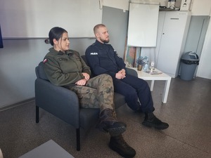 policjant z żołnierzem siedzą na kanapie