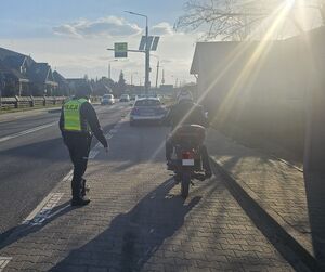 policjant podchodzi do motorowerzysty