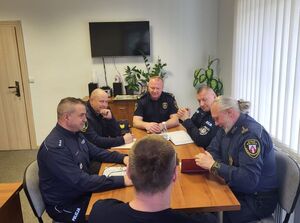 policjanci i strażnicy siedzą przy stole
