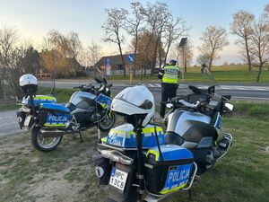 motocykle policyjne a w tle policjant stoi z miernikiem prędkości