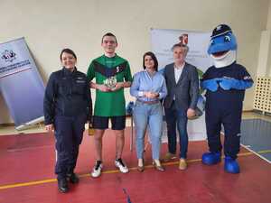 starosta i policjantka z laureatem najlepszego zawodnika turnieju