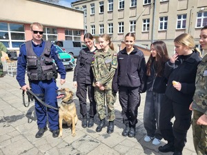 przewodnik z psem pozuje do zdjęcia z grupą osób