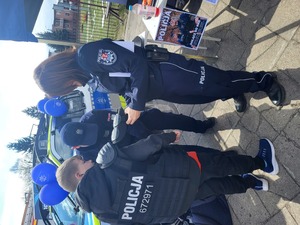 policjantka ubiera ucznia w strój policyjny