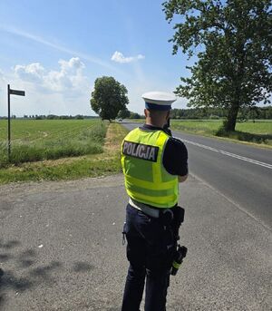 policjant mierzy prędkość na drodze
