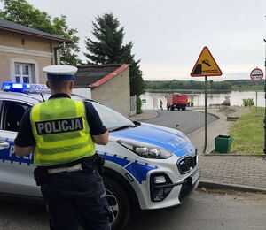 policjant stoi przy radiowozie