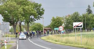 radiowóz prowadzi rowerzystów w deszczu