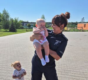 policjantka trzyma na rękach maluszka