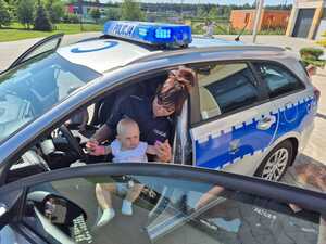 policjantka siedzi z dzieckiem na kolanach w samochodzie