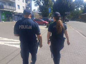 policjanci idą w kierunku bloku