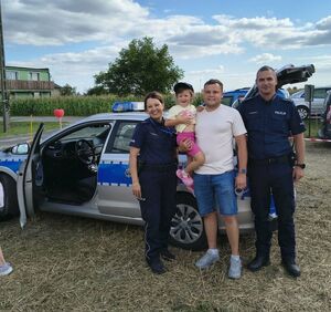 policjanci z mężczyzną z dzieckiem na ręku