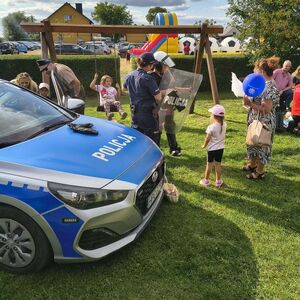 policjantka przy radiowozie zakładająca dziecku kamizelkę