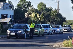 policjant sprawdza trzeźwość przy szereg samochodów