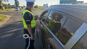 policjant stoi przy pojeżdzie