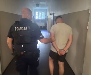 policjant prowadzi zatrzymanego