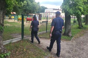 policjanci wchodzą na teren placu zabaw