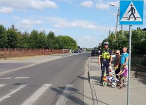 policjant stoi przy pasach z pieszymi