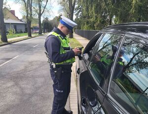 policjant stoi przy pojeżdzie